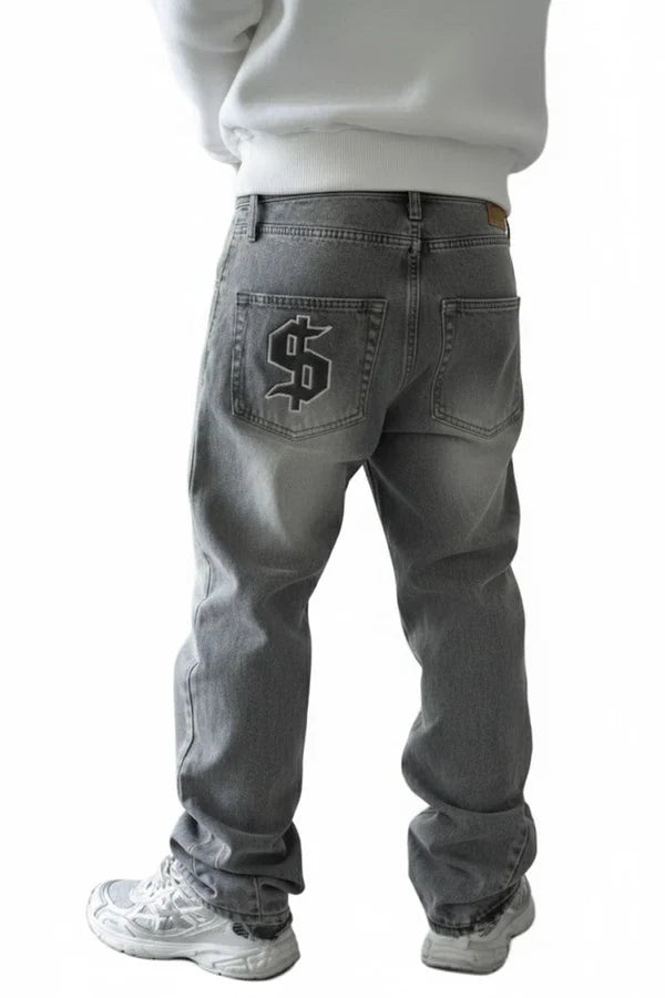A person shown from the back wearing gray denim jeans with a large black dollar sign patch on the back pocket, paired with a white sweatshirt and white sneakers, against a plain white background.