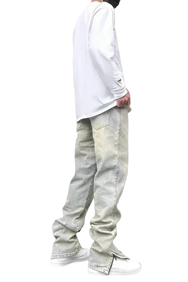 Person wearing light-colored jeans and a white long-sleeve shirt on a gray background