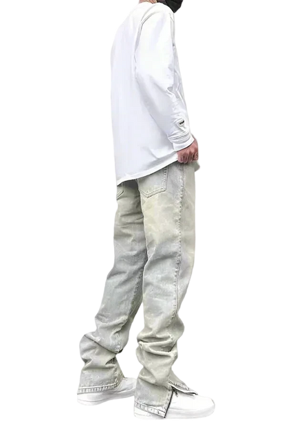 Person wearing light-colored jeans and a white long-sleeve shirt on a gray background