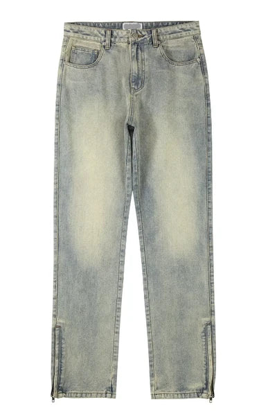 Light-wash blue denim jeans with a faded yellowish tint, featuring side slits at the ankles, shown flat against a white background.